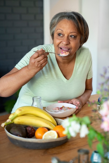 Gratis foto vooraanzicht senior vrouw aan het eten