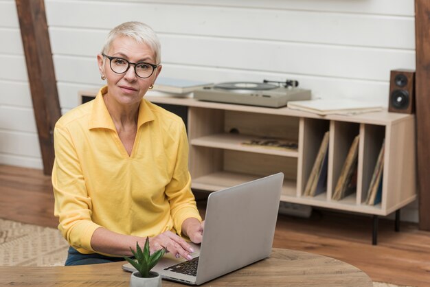 Vooraanzicht senior vrouw kijkt door het internet op haar laptop