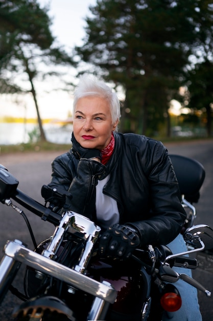 Vooraanzicht senior vrouw met motorfiets