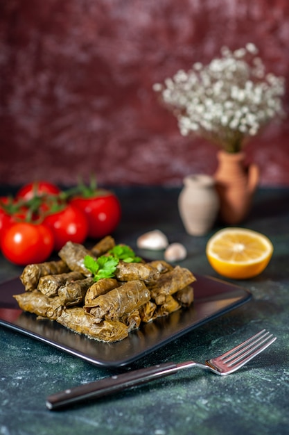 Vooraanzicht smakelijke blad dolma met rode tomaten op donkere achtergrond calorie-olie diner voedselsalade schotel vlees restaurant maaltijd