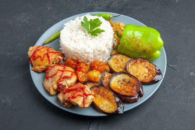 Vooraanzicht smakelijke gebakken aubergines met vlees gekookte rijst en rozijnen op donkere ondergrond