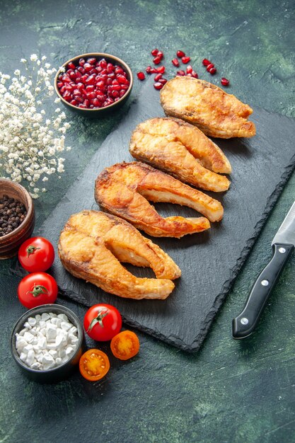 Vooraanzicht smakelijke gebakken vis met tomaten op donkere ondergrond schotel voedselsalade gebraden vlees zeevis koken maaltijd zeevruchten