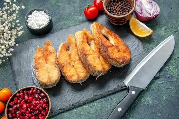 Vooraanzicht smakelijke gebakken vis op donkerblauwe ondergrond maaltijd peper vlees bak zeevruchten zeevruchten salade schotel koken