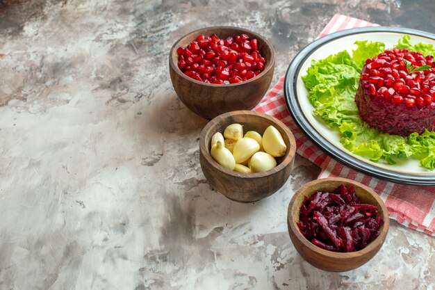 Vooraanzicht smakelijke granaatappelsalade op groene salade met kruiden op lichte foto voedsel maaltijd kleur gezondheid smakelijke vrije ruimte