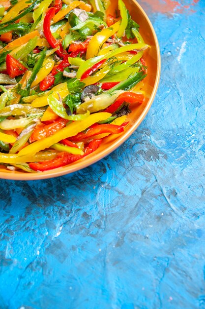 Vooraanzicht smakelijke groentesalade binnen bord op de blauwe tafel