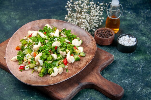 vooraanzicht smakelijke groentesalade binnen plaat op donkerblauwe achtergrond