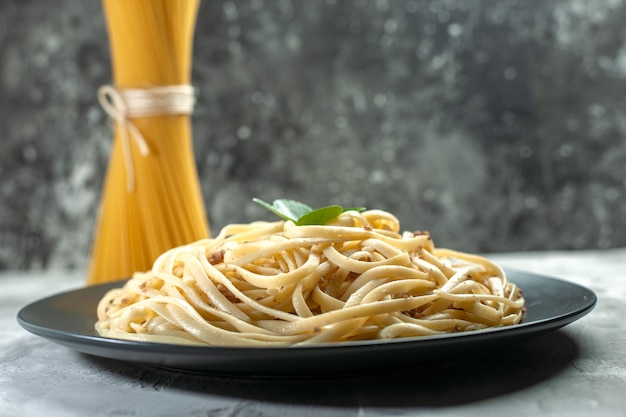 Vooraanzicht smakelijke italiaanse pasta met rauwe pasta op donkere kleur maaltijdschotel voedsel foto deeg