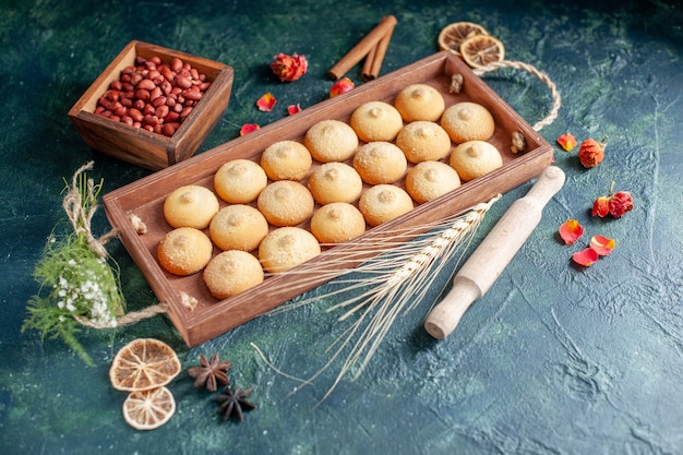 Gratis foto vooraanzicht smakelijke koekjes in houten kist op donkere ondergrond