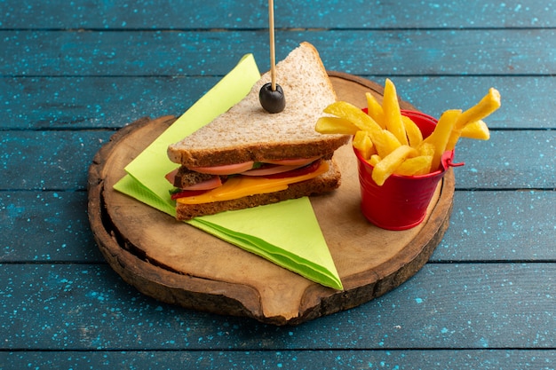 Gratis foto vooraanzicht smakelijke sandwich met kaas ham binnen met frietjes op blauw hout