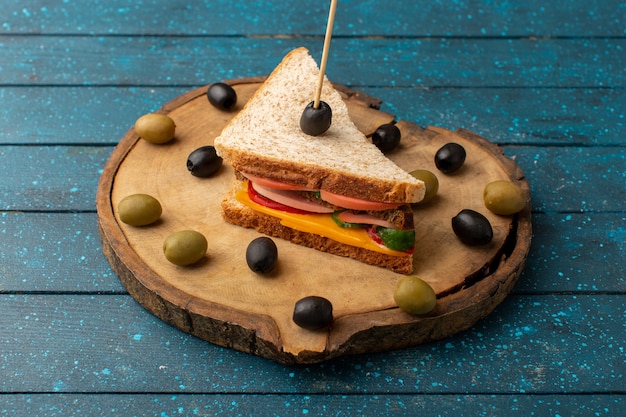 Vooraanzicht smakelijke sandwich met kaas ham binnen met olijven op blauw