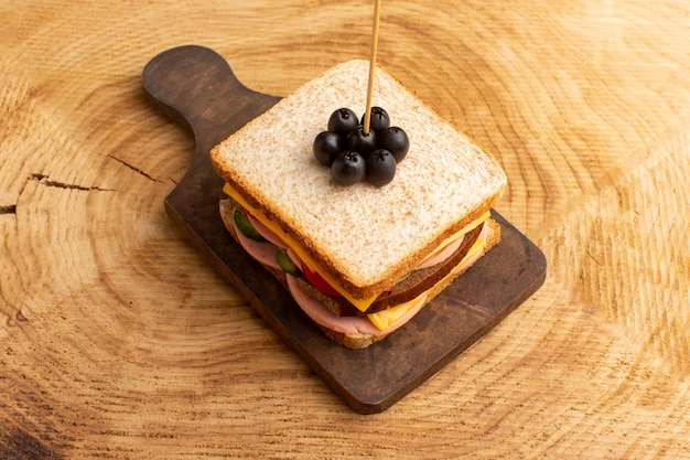 Vooraanzicht smakelijke sandwich met olijven ham tomaten groenten op stok