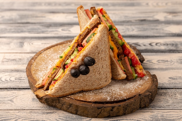 Vooraanzicht smakelijke toastsandwiches met kaasham binnen op hout