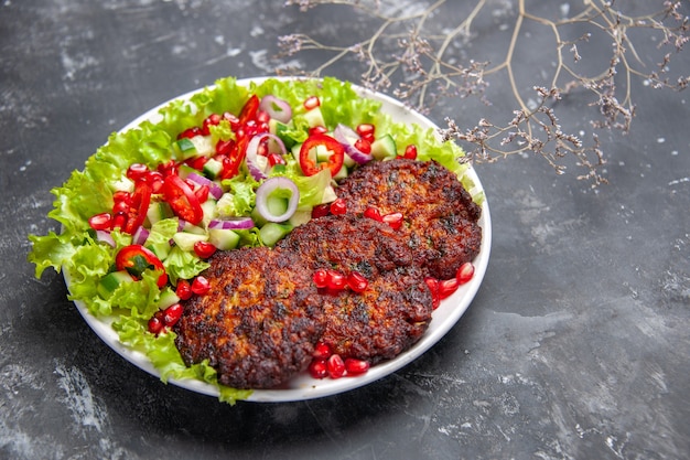 Vooraanzicht smakelijke vleeskoteletten met verse salade