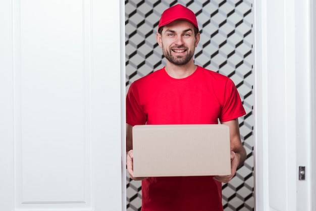 Vooraanzicht smiley levering man draagt rode uniform