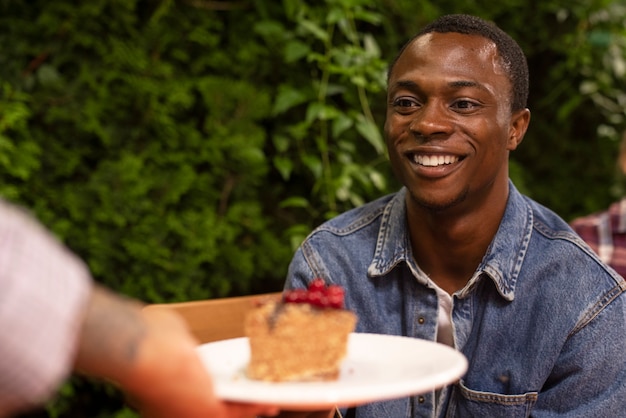 Gratis foto vooraanzicht smiley man met cake slice