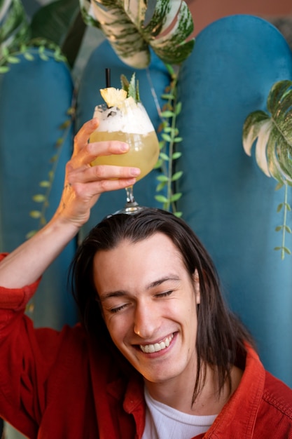 Gratis foto vooraanzicht smiley man met cocktail