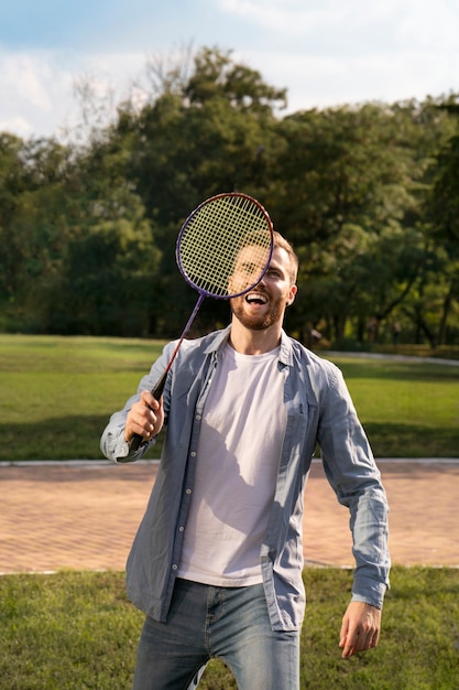 Gratis foto vooraanzicht smiley man spelen badminton