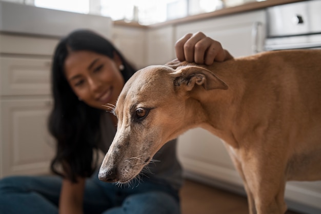 Gratis foto vooraanzicht smiley vrouw aaien hond