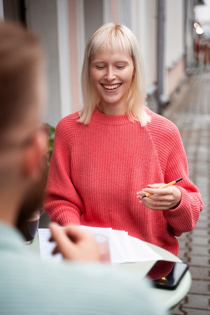 Gratis foto vooraanzicht smiley vrouw aan tafel