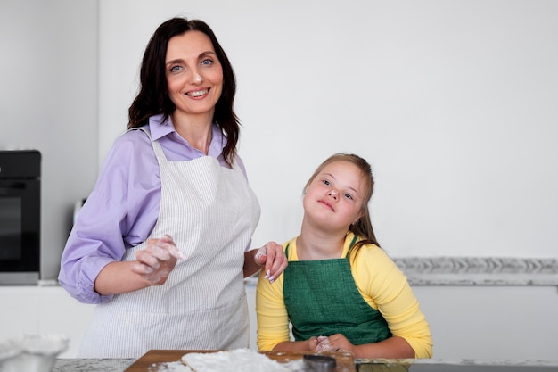 Gratis foto vooraanzicht smiley vrouw en meisje in de keuken