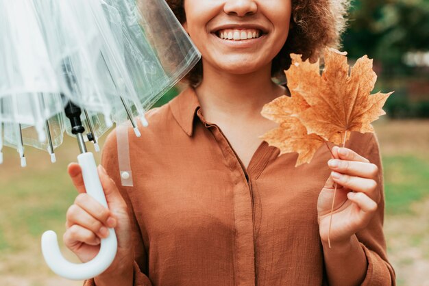 Vooraanzicht smiley vrouw met een blad en een paraplu