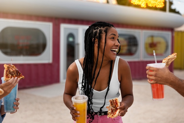 Gratis foto vooraanzicht smiley vrouw met pizza