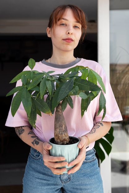 Vooraanzicht smiley vrouw met plantenpot