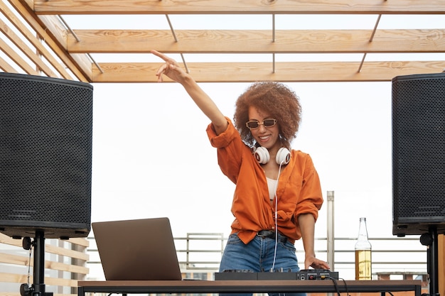 Gratis foto vooraanzicht smiley vrouw wordt dj