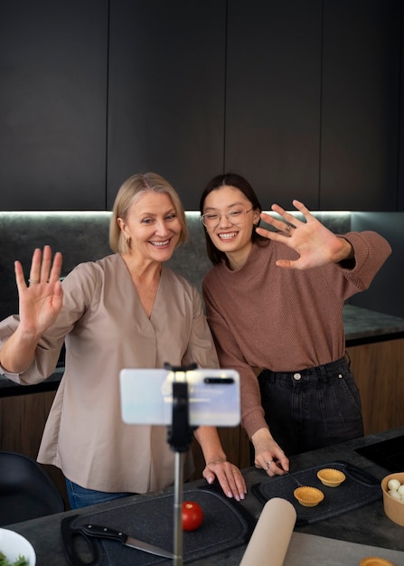 Gratis foto vooraanzicht smileyvrouwen die opnemen met smartphone