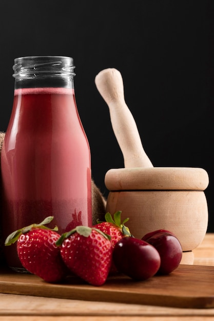 Vooraanzicht smoothie in fles met aardbeien en kersen