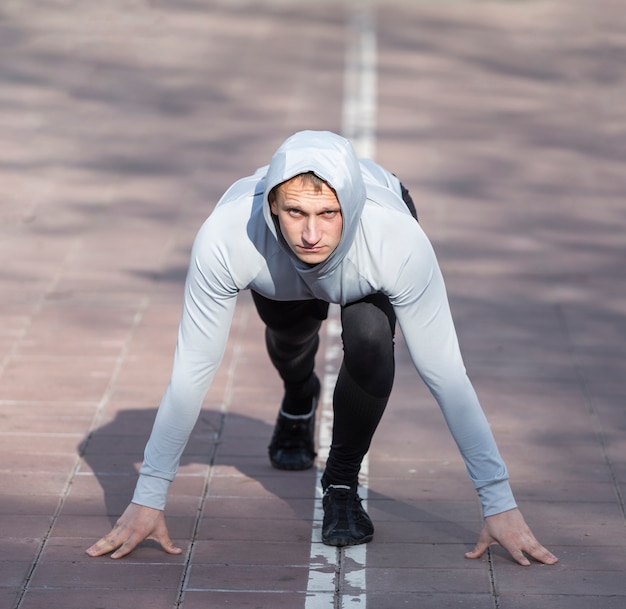 Gratis foto vooraanzicht sportieve man voorbereiden om te lopen