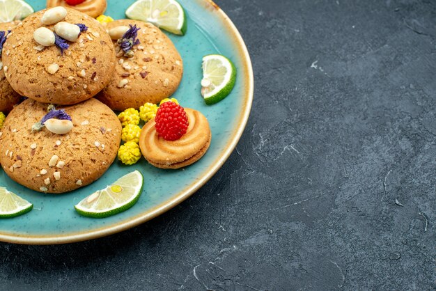 Vooraanzicht suikerkoekjes met plakjes citroen op grijze oppervlak taart cookie biscuit zoete cake