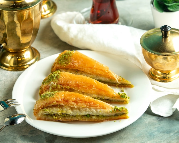 Gratis foto vooraanzicht traditionele turkse zoetheid turkse baklava met een glas thee