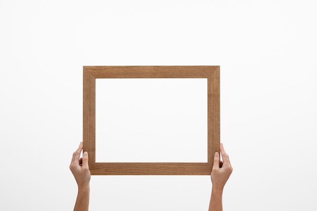 Vooraanzicht twee handen met groot houten frame