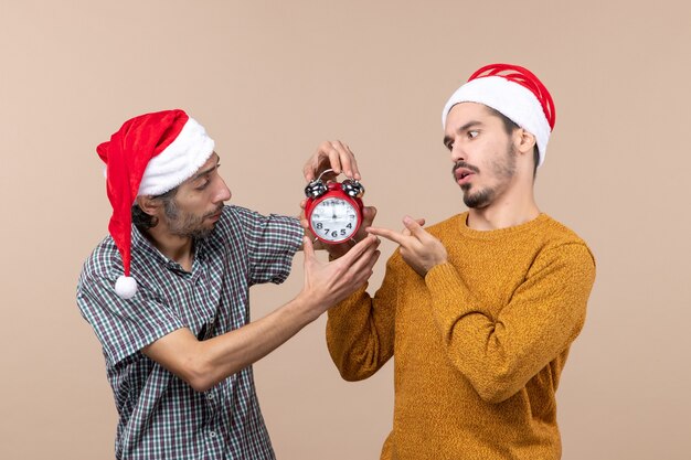 Vooraanzicht twee mannen met een wekker op beige geïsoleerde achtergrond