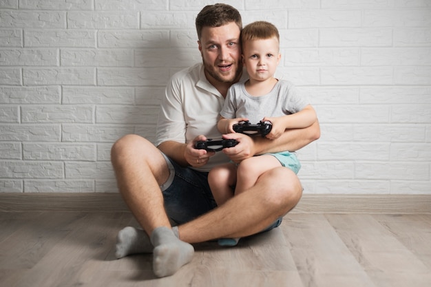 Vooraanzicht vader en zoon spelen van videogames