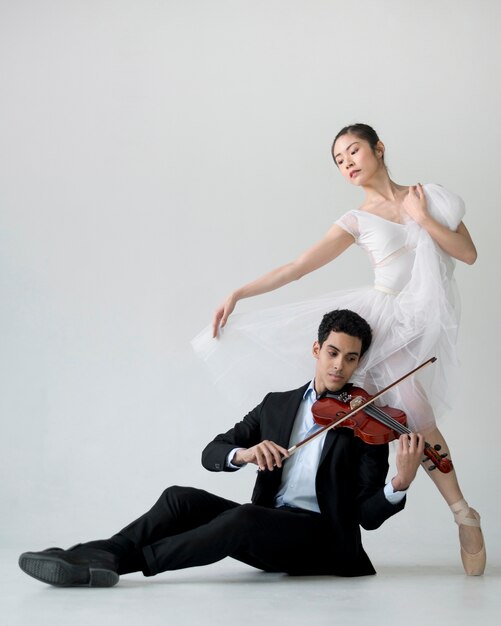 Vooraanzicht van ballerina en musicus spelen overtreden