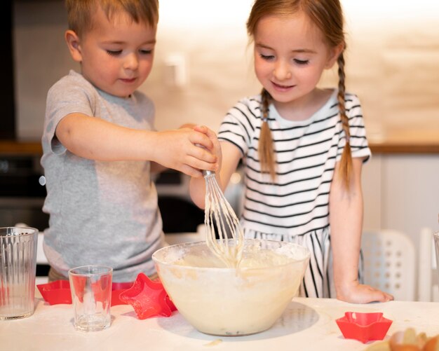 Vooraanzicht van broers en zussen die thuis koken