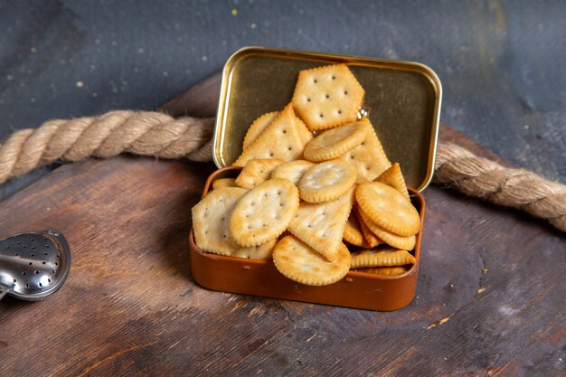 Vooraanzicht van chips en crackers op het houten bureau met touwen