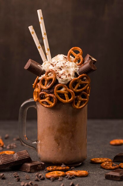 Vooraanzicht van chocolade milkshake met pretzels en rietjes