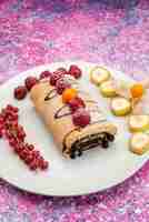 Gratis foto vooraanzicht van chocolade roll cake samen met veenbessen en fruit op het roze oppervlak