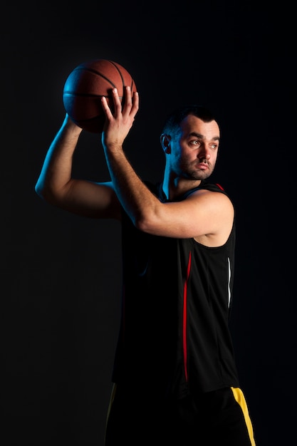 Vooraanzicht van de holdingsbal van de basketbalspeler omhoog