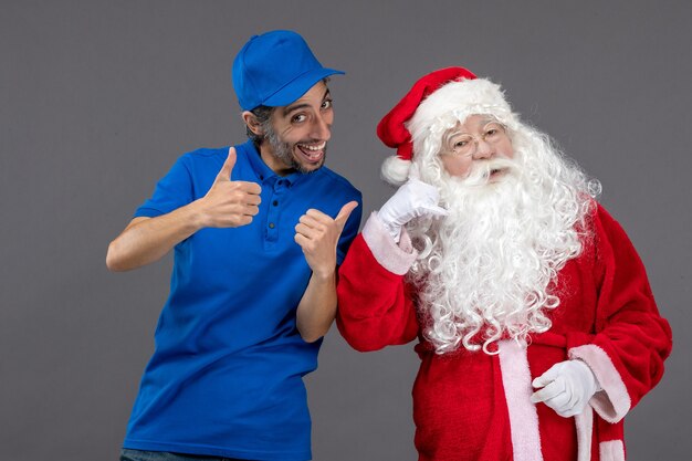 Vooraanzicht van de kerstman met mannelijke koerier op de grijze muur