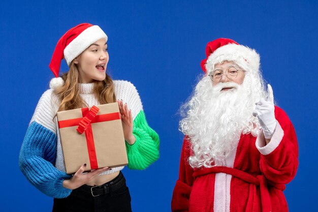 Vooraanzicht van de kerstman samen met vrouw die aanwezig is op de blauwe muur