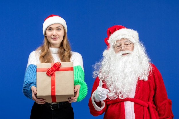 Vooraanzicht van de kerstman samen met vrouw die aanwezig is op de blauwe muur