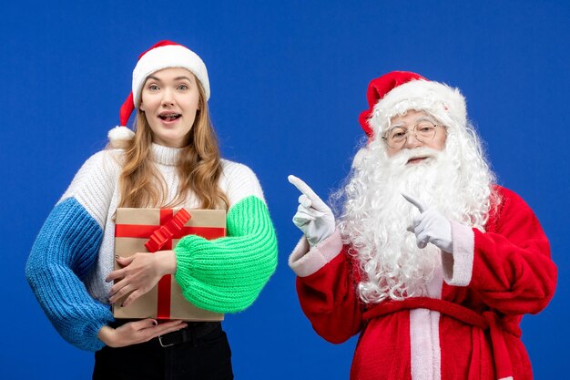 Vooraanzicht van de kerstman samen met vrouw die aanwezig is op de blauwe muur