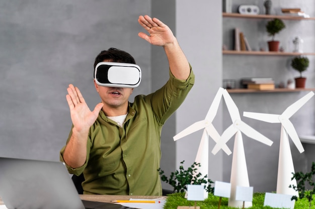 Vooraanzicht van de mens die aan een milieuvriendelijk windenergieproject werkt en virtual reality-headset gebruikt