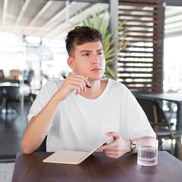 Vooraanzicht van de mens die buiten bij pub schrijft