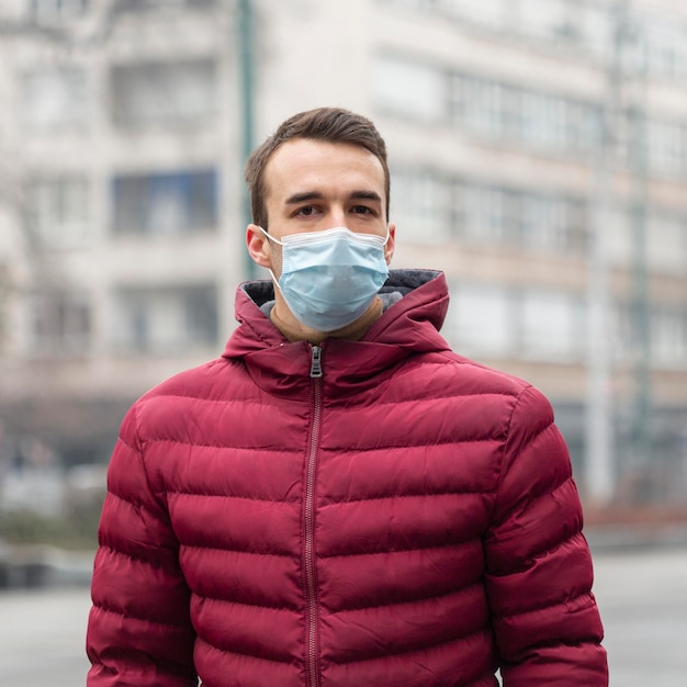 Vooraanzicht van de mens in de stad die medisch masker draagt