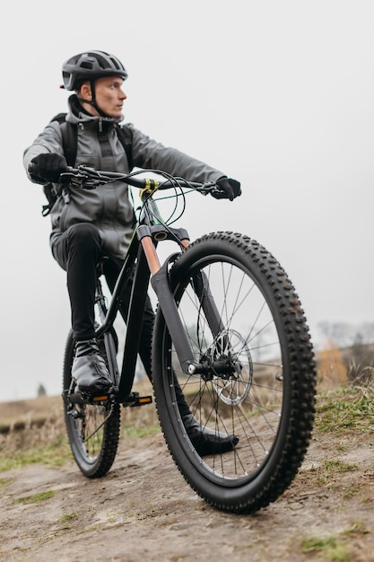 Vooraanzicht van de mens met een fiets in de bergen